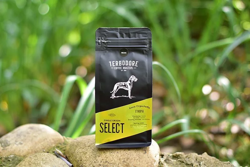 Terbodore SELECT Ethiopia Kana Yirgacheffe | TERBODORE Coffee Roasters Terbodore Select coffee bag on a stone - background grass - Terbodore