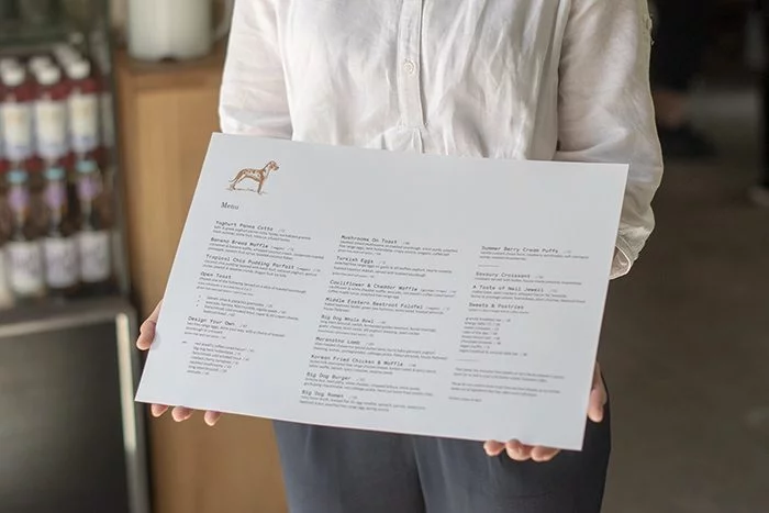 Big Dog Cafe Franschhoek summer menu being held by a waiter - Terbodore