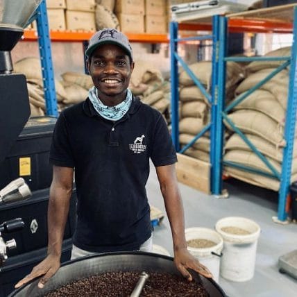 Man standing with coffee beans ready for packaging - Terbodore